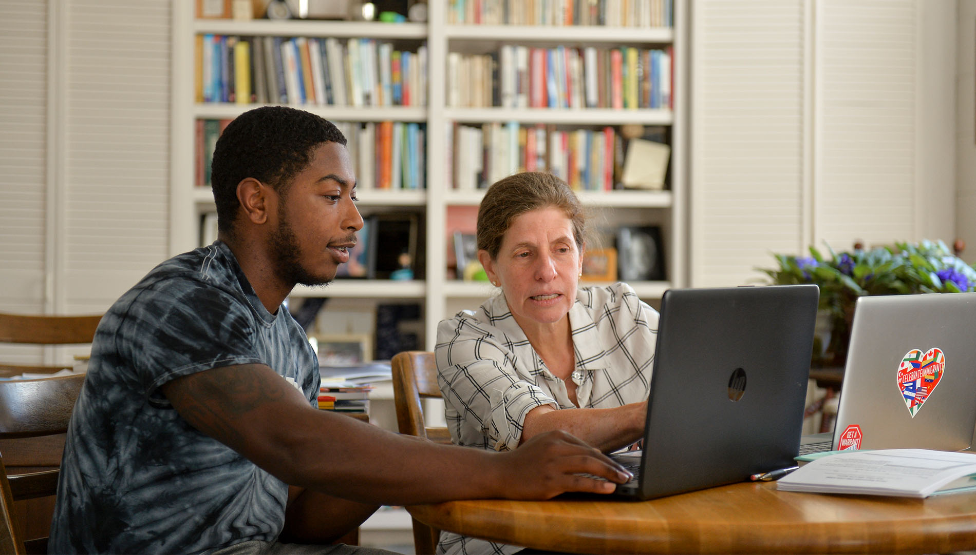 student and professor pointing to computer